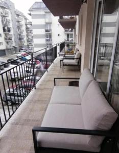 a white couch on a balcony of a building at Yoa Apartaments in Floreşti