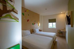 Postel nebo postele na pokoji v ubytování Ascent Hotel & Cafe Malang
