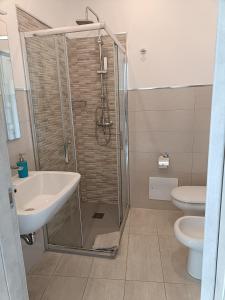 a bathroom with a shower and a sink and a toilet at SeA Beach Home in Torre Lapillo +37 photos
