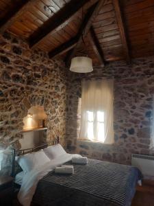 a bedroom with a bed and a window at Andromahi Stone House in Stemnitsa