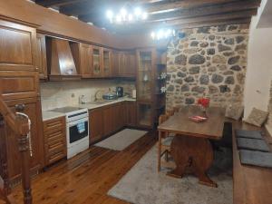 a kitchen with a table and a stone wall at Andromahi Stone House in Stemnitsa