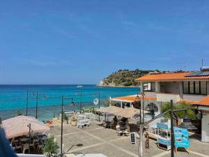 a view of a beach with a building and the ocean at Borgo dei Pescatori - SUL MARE in Capo Vaticano