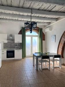 a kitchen with a table and a large window at Home Ringo in Belvedere Marittimo