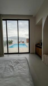 a large bedroom with a view of a swimming pool at Raml villa in Ras al Khaimah