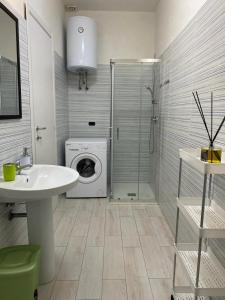 a bathroom with a sink and a washing machine at Home Ringo in Belvedere Marittimo