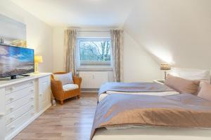 a bedroom with two beds and a flat screen tv at Hjertets Hus in Humptrup