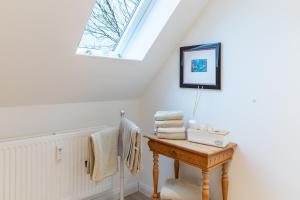 a bathroom with a skylight and a table with towels at Hjertets Hus in Humptrup +44 photos