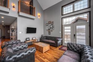 a living room with leather couches and a tv at Blanc40 in Stoneham
