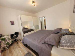 a bedroom with a large bed and a mirror at Apartment für 4 Personen mit Jacuzzi und Pool in Lovran