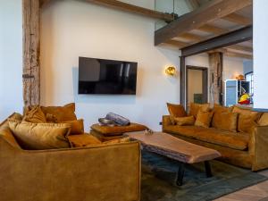 a living room with brown furniture and a flat screen tv at Scheune 1746 in Tating
