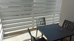 a table and two chairs and a table and a fence at SeA Beach Home in Torre Lapillo
