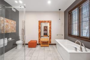 a bathroom with a tub and a sink and a toilet at Blanc40 in Stoneham +33 photos