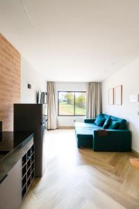 a living room with a green couch in a room at TABULEIRO loft novo, moderno e espaçoso in Ouro Preto