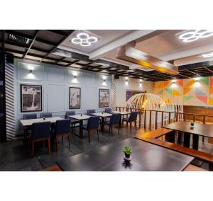a dining room with tables and blue chairs at Purple Brigade, Bangalore in Bangalore