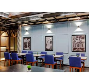 a dining room with tables and blue chairs at Purple Brigade, Bangalore in Bangalore