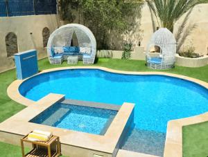 a swimming pool in a yard with a gazebo at Luxury Royal Blue Family Villa 8pers private pool in Hurghada