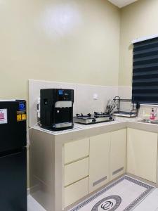 a kitchen with a black refrigerator and a microwave at Homestay Teratak Nailufar in Pekan