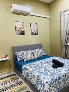 a bedroom with a bed and a air conditioner at Homestay Teratak Nailufar in Pekan
