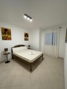 a white bedroom with a bed and a window at Larriba Santa Maria by RPG Group in Santa Maria