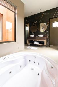 a bath tub in a bathroom with a large window at TABULEIRO loft novo, moderno e espaçoso in Ouro Preto +61 photos