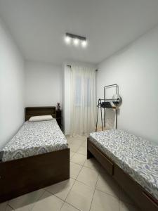 a bedroom with two beds and a window at Larriba Santa Maria by RPG Group in Santa Maria +4 photos