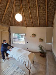 a person making a bed in a room at Casa Nuestra Hotel Boutique y Experiencias para Compartir in Malinalco
