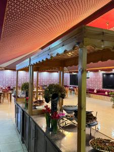a restaurant with a counter with flowers and tables at Golden Stars Luxury Camp Wadi Rum in Wadi Rum