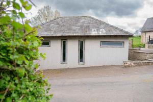 a white house with a garage at The Cartshed in Llanvetherine