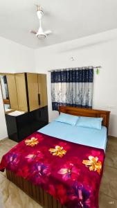 a bedroom with a large bed with a red blanket at Happy Homes in Palakkad
