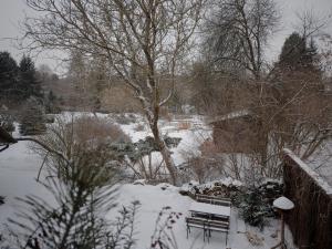 a bench in the snow next to a river at Pokoje gościnne Fermata in Kazimierz Dolny