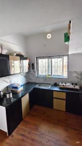 a kitchen with a black counter and two windows at Happy Homes in Palakkad