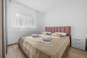 a bedroom with a large bed with two pillows on it at Apartment Lola in Peroj