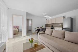 a living room with a couch and a kitchen at Apartment Lola in Peroj