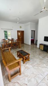 a living room with a table and chairs at Happy Homes in Palakkad +13 photos