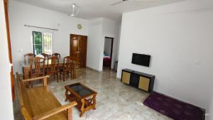 a living room with a table and a dining room at Happy Homes in Palakkad