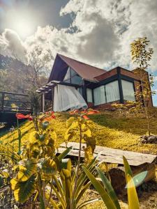 a house on a hill with flowers in front of it at Chalé Mirante dos Anjos in Rodeio