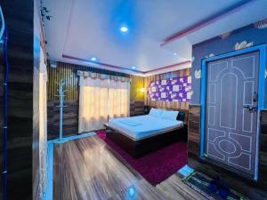 a bedroom with a bed and a door at Hotel Aanandalok in Pānigata