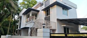 a white house with a staircase in front of it at Happy Homes in Palakkad