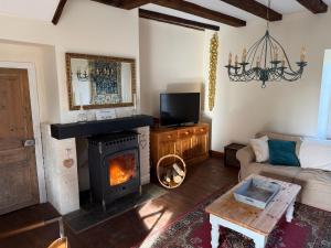 a living room with a fireplace and a couch at Chez le Cavalier in Génis