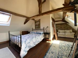 a bedroom with a bed in a room with beams at Chez le Cavalier in Génis
