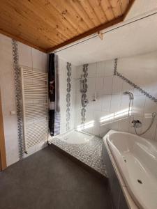 a bathroom with a bath tub and a sink at Mittagsspitz am Bauernhof in Flattach +12 photos