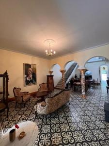 a lobby with a staircase and a room with chairs at Posada La Pastora Colonial in Caracas