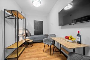 a living room with a table and a couch at Centrum Prestige Apartments in Rybnik