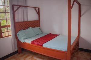 a bed with a wooden frame in a room at Makinihomestay in Arusha