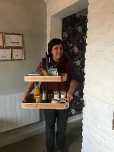 a woman holding a serving tray of food at B&B beApart in Ieper