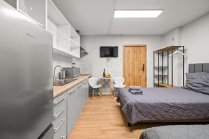 a small bedroom with a bed and a kitchen at Central Platinum Apartments 5 Studio z aneksem kuchennym i tarasem in Rybnik