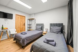 a bedroom with two beds and a table with a chair at Central Platinum Apartments 5 Studio z aneksem kuchennym i tarasem in Rybnik