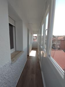 a hallway of a house with windows and a wooden floor at Alojamiento La Tortuga in Las Navas del Marqués +6 photos
