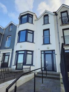 an image of a white house with black windows at West Strand Snug in Portrush
