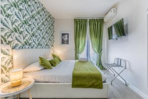a bedroom with a bed with a green blanket at Casa flowers in Ciampino